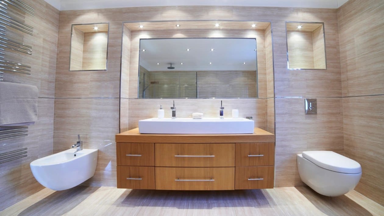 A bathroom with two sinks and a large mirror.