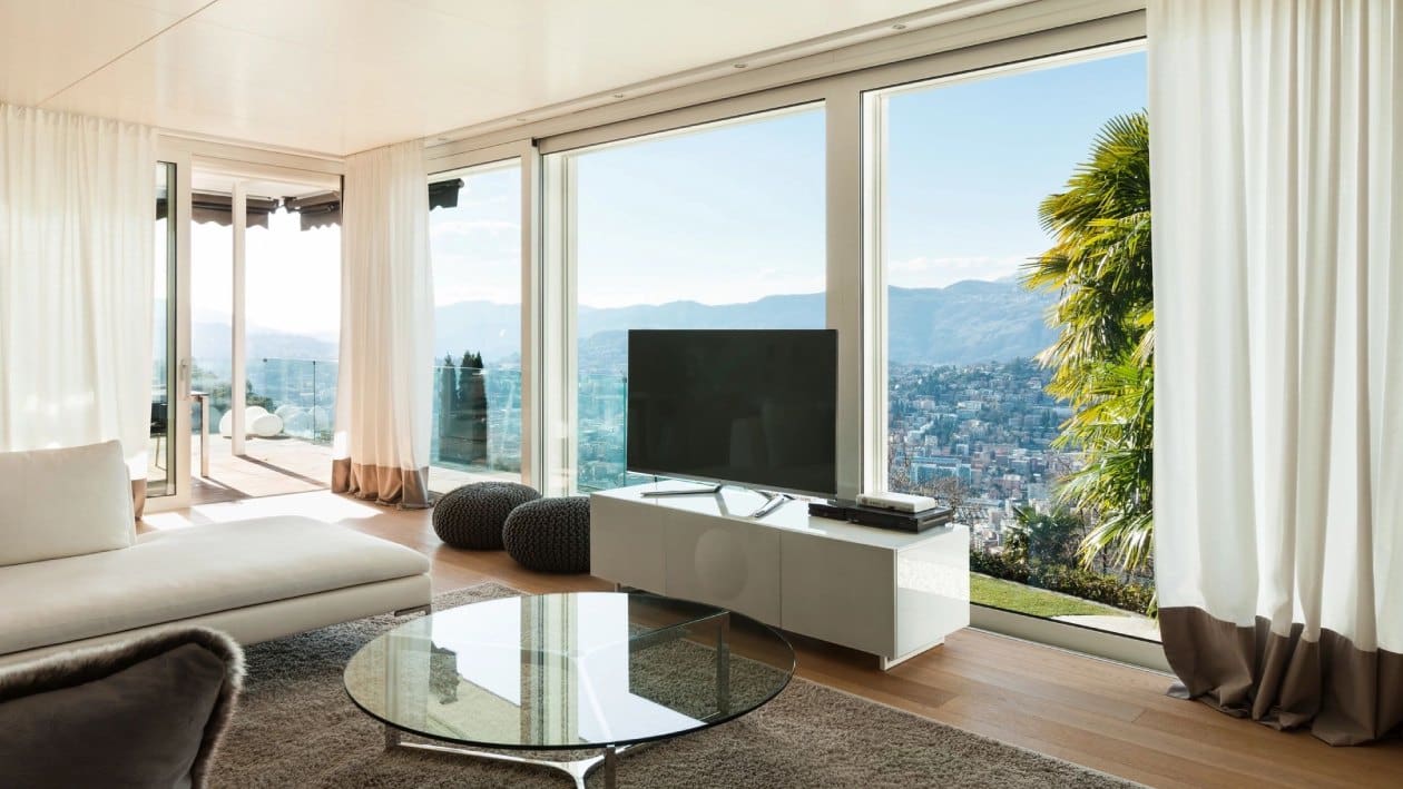 A living room with large windows and a view of the mountains.