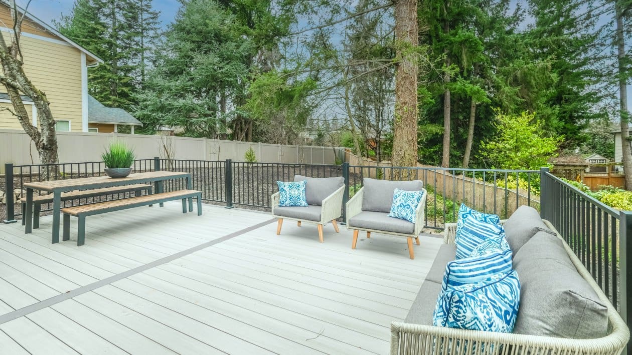 A deck with benches and chairs in the middle of it.