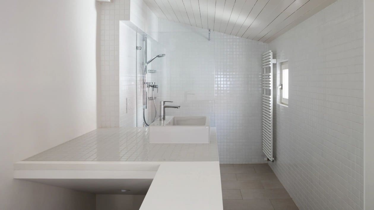 A bathroom with white walls and tile floors.